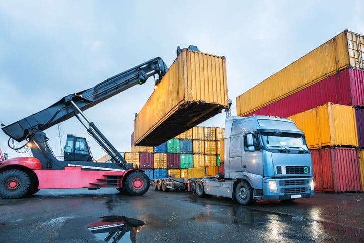 Truck loading a shipping container at a freight terminal